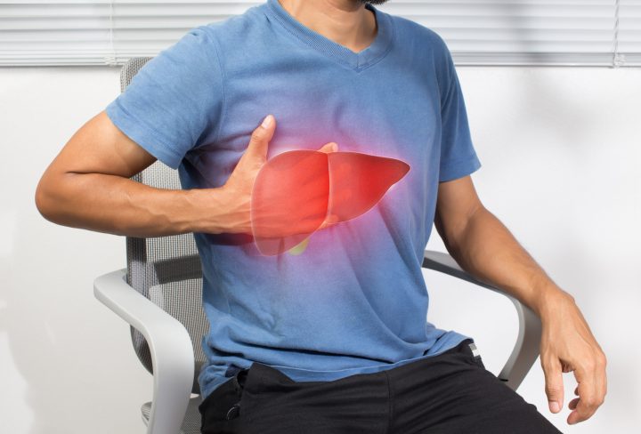 The illustration of liver is on the man's body against gray background. A men with hepatitis and fatty liver problem.