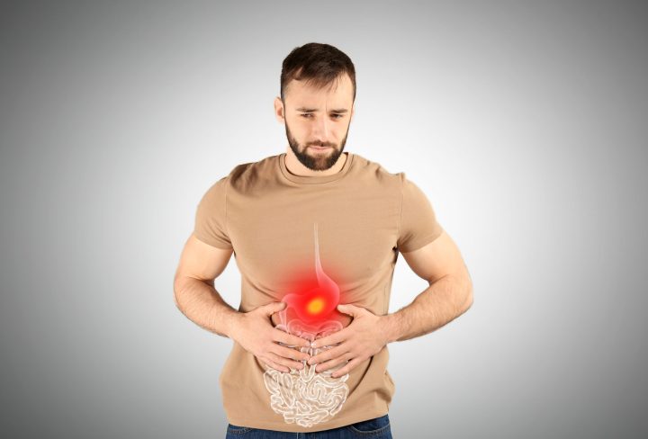 Healthcare service and treatment. Man suffering from abdominal pain on grey background. Illustration of gastrointestinal tract